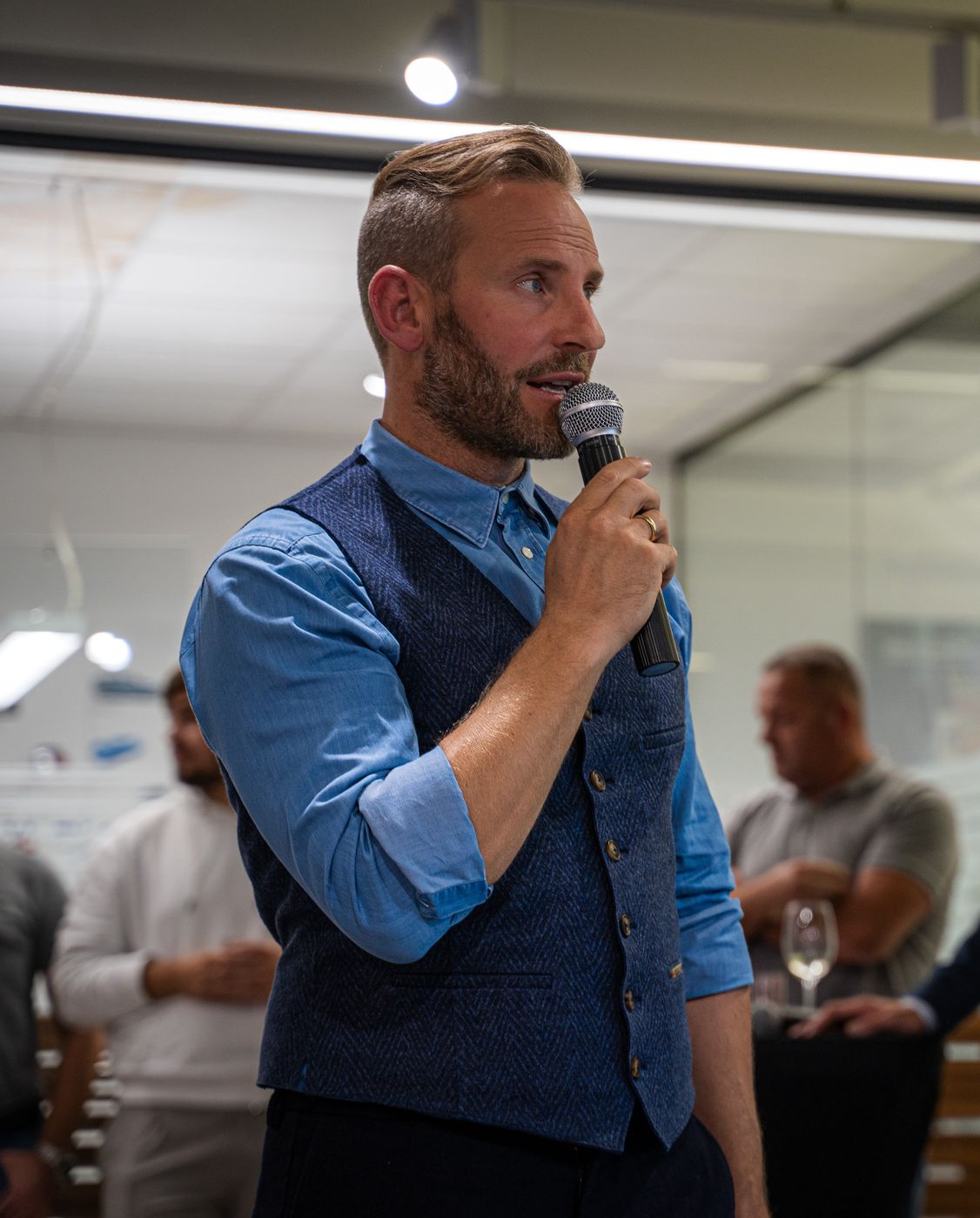 Sebastian Weber moderiert mit Mikrofon bei einer Veranstaltung