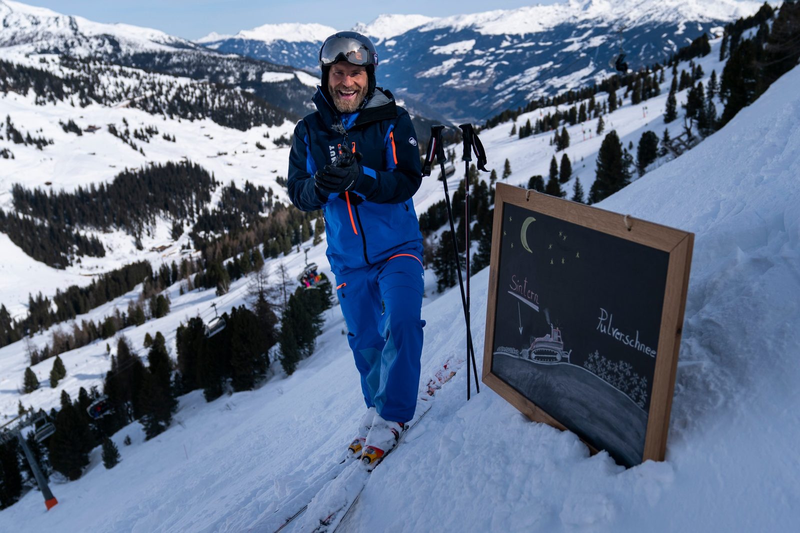 Sebastian Weber auf Skiern neben der Wettertafel „Sintern – Pulverschnee“
